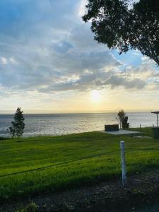 a field of grass with the ocean in the background at Lions Camp Kanga in Dittmer