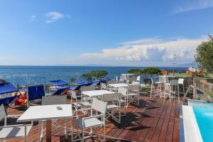 uma fila de mesas e cadeiras junto a uma piscina em Hotel Il Faro em Sorrento