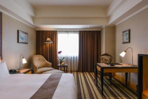 a hotel room with a bed and a desk at THE LEES Hotel in Kaohsiung