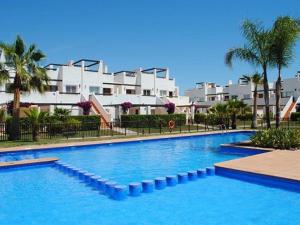una grande piscina di fronte ad alcuni edifici di 3 Bed Apartment Condado de Alhama Golf Resort ad Alhama de Murcia