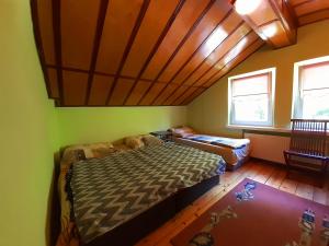 a bedroom with a bed and a wooden ceiling at Pensjonat Osemka in Lewin Kłodzki +9 photos