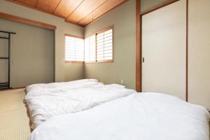 Postel nebo postele na pokoji v ubytování Tabist Futaba Ryokan Tatsuno