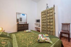 1 dormitorio con cama, silla y espejo en Casa Sabina - Villa Perenquén, en Guía de Isora