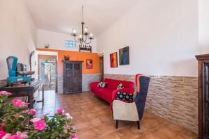 ギア・デ・イソラにあるCasa Cardón - Villa Perenquénの赤いソファとレンガの壁が備わるリビングルーム