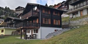 dom z balkonami na zboczu wzgórza w obiekcie Chalet Valaisia w mieście Riederalp
