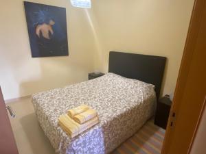 ein Schlafzimmer mit einem Bett mit Handtüchern darauf in der Unterkunft Apartamento acolhedor numa das mais belas praias do centro de Portugal in Pataias