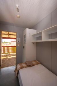 1 dormitorio con 1 cama y balcón en STORK RD BUDGET ROOMS - PRIVATE ROOMS WITH SHARED BATHROOMS access to POOL en Longreach