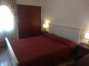 アルマカオ・デ・ペラにあるBeira Mar Terrace Apartmentのベッドルーム1室(赤いプライドの毛布付きのベッド1台付)