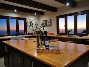 una cucina con tavolo in legno, bottiglie di vino e bicchieri di My hell Village a Tijarafe