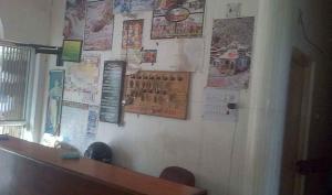 Una pared con carteles y papeles. en Hotel Om Shiv Shankar, en Uttarkāshi