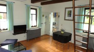 uma sala de estar com uma mesa e algumas janelas em Ferienhaus Villa Bourguet em Bad Liebenstein