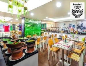 a dining room with tables and chairs in a restaurant at favehotel Gatot Subroto Jakarta in Jakarta