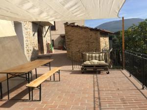 a patio with a table and a bench and a building at Umbria In Bike B&B in Foligno