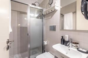 a bathroom with a shower, sink, and mirror at Apartamentos Villa Bolhao in Porto