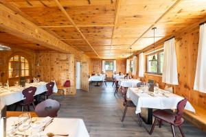 ein Esszimmer mit Tischen, Stühlen und Holzwänden in der Unterkunft Hotel Seelaus in Alpe di Siusi