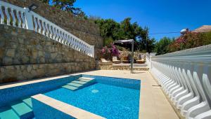a swimming pool next to a stone wall at Apartments Happy Island Rab in Rab
