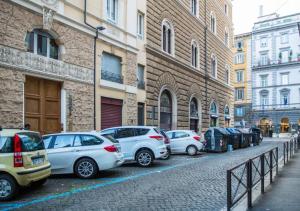 uma fila de carros estacionados numa rua ao lado de edifícios em Atlantis Inn Roma em Roma