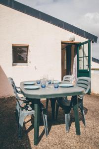 een groene tafel met stoelen eromheen bij Terres de France - Domaine de Kerioche in Rochefort-en-Terre
