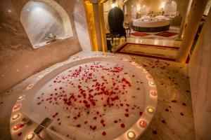 a bathroom with a white plate with red sprinkles on it at Divan Cave House in Göreme