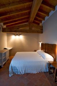a bedroom with a large white bed and wooden ceilings at Corte Breda, Agriturismo Bed&Breakfast in Chiari