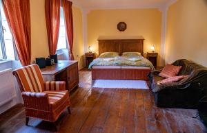 een slaapkamer met een bed, een bureau en een stoel bij Holiday Home Banská Štiavnica in Banská Štiavnica