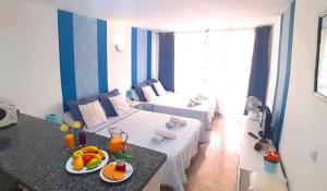 een kleine woonkamer met een tafel met fruit erop bij Apartment near to the ocean in touristic center zone in Playa Fañabe