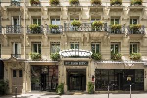 un gran edificio con muchas ventanas y macetas de flores en Hôtel Elysées Régencia, en París