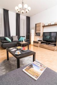 a living room with a couch and a tv at Stephansdom Premium Apartments in Vienna