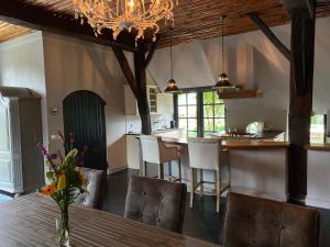 une cuisine avec une table et des chaises ainsi qu'une salle à manger dans l'établissement Hofstede "Den Hul"- Riant & Authentiek verblijf, à Barneveld