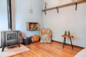 a living room with a wood stove and a chair at Finca Les Coves in Jijona