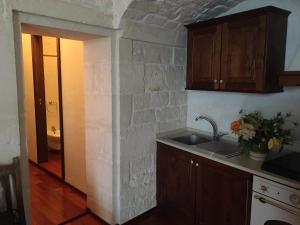 a kitchen with a sink and a brick wall at B&B San Martino in Martina Franca