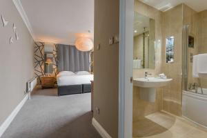a bathroom with a sink and a bed in a room at Park Inn by Radisson Shannon Airport in Shannon