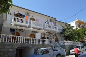 a white house with balconies and a truck parked in front of it at Two Brothers Parga in Parga