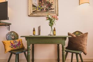 a table with two chairs and a vase of flowers on it at Das Bräu ORIGINAL in Lofer