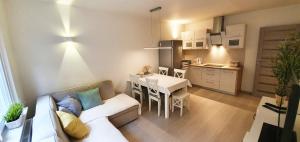 a living room with a white couch and a kitchen at Solano Apartments in Świnoujście