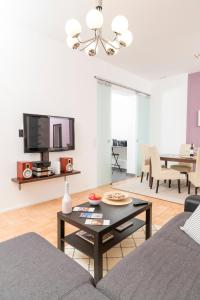 a living room with a table and a tv at Stephansdom Premium Apartments in Vienna