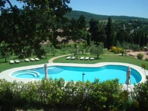 a swimming pool in a yard with chairs and trees at Sant'Antonio Country Resort in Montepulciano