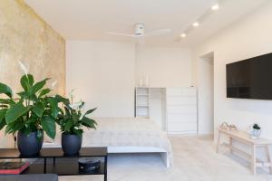 um quarto com uma cama e dois vasos de plantas em Uni Apartament em Lódź