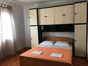 a bedroom with a large bed with white cabinets at Apartmani Vilma Pakoštane in Pakoštane