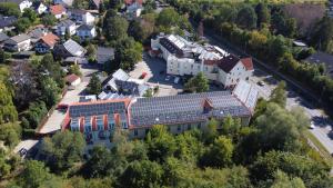 une vue aérienne sur un bâtiment doté de panneaux solaires sur son toit dans l'établissement Four Stars by City Hotel, à Meckenheim