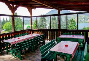 a restaurant with green tables and benches in a room with windows at Vila Ozon 90 in Colibiţa