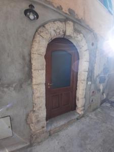 a wooden door in a stone archway in a building at B&B Residenza Cardinale in Tropea