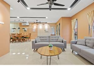 ein Wohnzimmer mit Sofas und einem Tisch in der Unterkunft Suraya Homestay Semi-D in Sepang