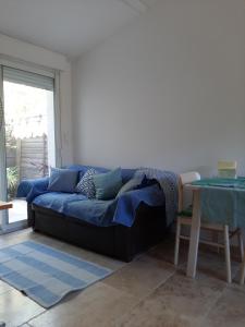 a blue couch in a living room with a table at Studio Indépendant Millénaire in Montpellier
