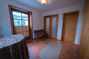 Zimmer mit einem Tisch, einer Bank und einem Fenster in der Unterkunft Casa dos Peliteiros in Vilarinho