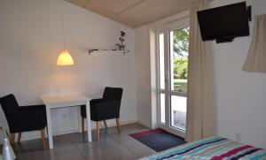 Schlafzimmer mit einem Schreibtisch, einem Bett und einem Fenster in der Unterkunft Bed & Breakfast Tistrup in Tistrup