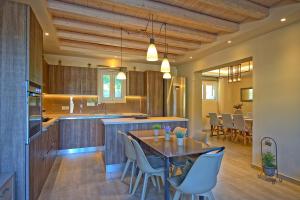 una cucina e una sala da pranzo con tavolo e sedie di Luxury Villa Matzourana by PosarelliVillas a Gardeládes