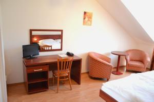 Schlafzimmer mit einem Schreibtisch, einem TV und einem Bett in der Unterkunft Apart Hotel Susa in Prag