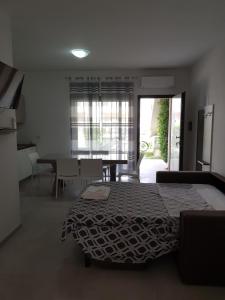 a bedroom with a bed and a dining room with a table at Appartamento Miele in Zambrone