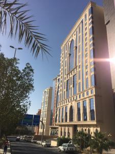 فندق ملاك الصفوة في مكة المكرمة: مبنى في مدينة فيه سيارات تقف في موقف للسيارات